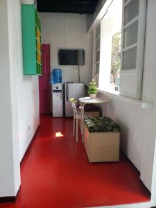 Il comprend une cuisine dotée d'un sol rouge, d'une table et d'un réfrigérateur. dans l'établissement Dormitels.ph The Fort BGC, à Manille