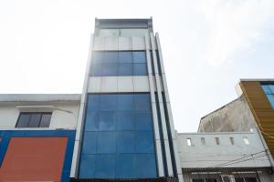 RedDoorz Plus @ Danau Sunter Utara في جاكرتا: مبنى طويل وبه نوافذ زجاجية على شارع