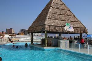 a pool at a resort with people in the water at Resort Urbano Laguna del Mar in La Serena