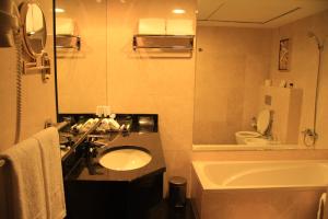 a bathroom with a sink, toilet and bathtub at Trianon Royal Hotel in Abu Dhabi