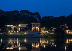 a house on the shore of a lake at night at Photharam126 Resort in Ban Khlong Ta Khot
