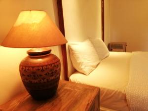 a lamp sitting on a table next to a bed at Coco Country Homes in Melaka