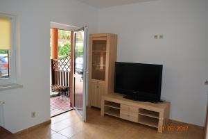 a living room with a television on a entertainment center at Aga Pokoje Gościnne - Tylko dla dorosłych in Rewal