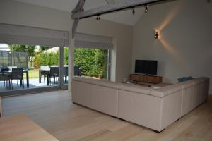 una sala de estar con un gran sofá blanco en Vakantiewoning Den Landman, en Nieuwpoort