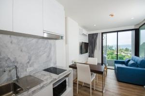 a kitchen and living room with a blue couch at Aristo2 Surin Condo in Surin Beach