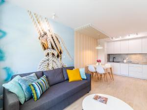 a living room with a couch and a kitchen at Apartamenty Baltia Kołobrzeg - Bliżej Morza in Kołobrzeg