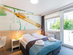 a bedroom with a bed with towels on it at Apartamenty Baltia Kołobrzeg - Bliżej Morza in Kołobrzeg