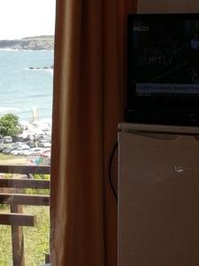 a television sitting on top of a curtain next to a window at South Beach Villa in Sinemorets