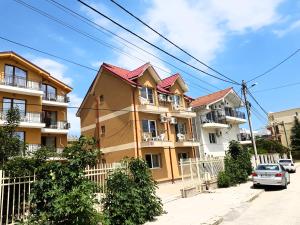 a building with a car parked in front of it at Vilele Liliana in Mamaia Sat/Năvodari