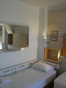 a bedroom with a large mirror above a bed at Spitakia in Vourkari