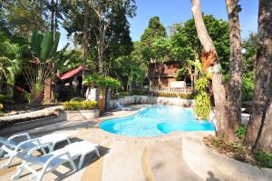 a swimming pool with two white chairs and trees at Railay Viewpoint Resort in Railay Beach +42 photos