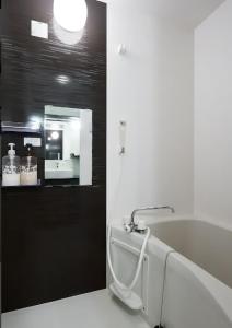a bathroom with a bath tub and a mirror at The Wonder At Stay-Tengachaya- in Osaka