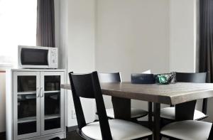 a dining room table with chairs and a microwave at The Wonder At Stay-Tengachaya- in Osaka
