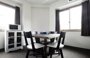 a table and chairs in a room with windows at The Wonder At Stay-Tengachaya- in Osaka
