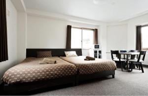 a bedroom with a bed and a table and chairs at The Wonder At Stay-Tengachaya- in Osaka