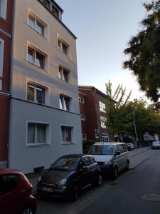 ミュンスターにあるFerienwohnung im Stadtzentrumの高層ビルの隣に2台駐車