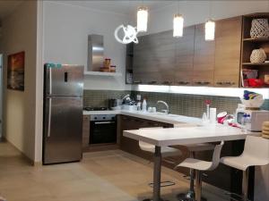 una cucina con frigorifero in acciaio inossidabile e tavolo di Villa Zizzari A Due Passi Dal Mare a Torre Lapillo