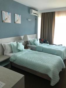 a hotel room with two beds and a window at Alcor Beach Hotel in Mamaia