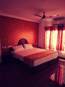 a bedroom with a large bed with red walls and windows at Rexon Residency in Kattappana