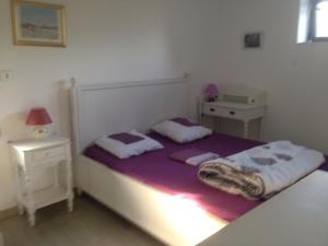 a small bedroom with a bed and a night stand at La Greve Saint Michel in Beauvoir