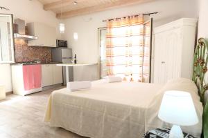 1 Schlafzimmer mit einem großen weißen Bett und einer Küche in der Unterkunft loft Pasquale in Cefalú