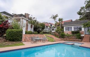 a house with a swimming pool and a table and chairs at Hathaway Guest House in East London