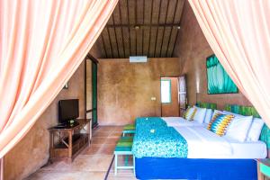 - une chambre avec un lit, une télévision et des rideaux dans l'établissement Villa Jeruk II 2 Bedrooms Umalas Canggu, à Canggu