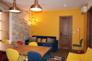 a living room with yellow walls and a blue couch at byGRACE Apartment in Split