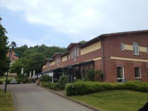 a red brick building with a sidewalk in front of it at Ferienwohnung "Kranich" im Ferien-Resort Rügen in Sagard