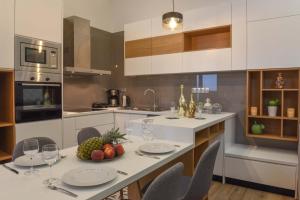 a kitchen with a table with a bowl of fruit on it at Residenza Rithymna Centro with a private roof terrace and hot tub in Rethymno +37 photos