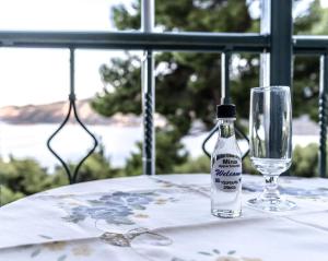 a bottle of alcohol sitting on a table next to a glass at Mina Apartments in Poros