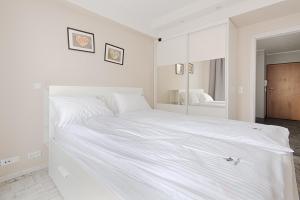 biała sypialnia z dużym białym łóżkiem w obiekcie Imperial Apartments - Baltica w mieście Sopot