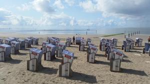 a row of chairs on a sandy beach at Dat Inselhuus in Norden