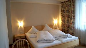A bed or beds in a room at Hotel Garni ALPINA