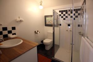 a bathroom with a toilet and a sink and a shower at Wallace Lodge - PID-STRA-16871 in Braidwood