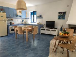 cocina con armarios azules, mesa y sillas en Casa Vacanze MARESOLE, en Mattinata