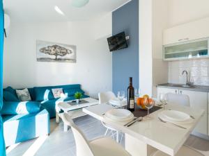 un soggiorno con tavolo e divano blu di Lush Apartment in Omi alj near Seabeach a Omišalj (Castelmuschio)