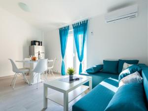 un soggiorno con divano blu e tavolo di Lush Apartment in Omi alj near Seabeach a Omišalj (Castelmuschio)