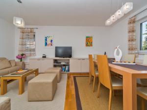 a living room with a dining room table and a couch at Spacious apartment in Dubrovnik with private garage in Dubrovnik