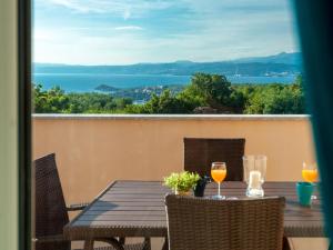 een tafel met twee glazen wijn op een balkon bij Lush Apartment in Omi alj near Seabeach in Omišalj