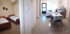 a room with two beds and a table and chairs at Mina Apartments in Poros