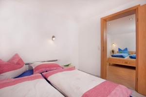 a bedroom with a bed with pink and white sheets at Ferienhaus Hochwimmer in Hollersbach im Pinzgau