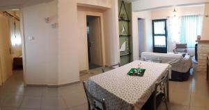 a living room with a table and a room with a bed at Mina Apartments in Poros