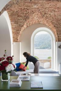 a woman standing on a couch in a room with a window at Grand Hotel Portovenere in Portovenere