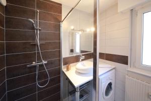 a bathroom with a shower and a sink and a washing machine at L'étoile du Nord - 1 PARKING GRATUIT in Colmar +19 photos