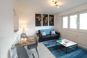 a living room with a couch and a table at L'étoile du Nord - 1 PARKING GRATUIT in Colmar