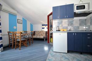 a kitchen and dining room with a table and chairs at Apartments Sersic in Baška