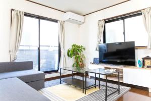 a living room with a couch and a tv at Tokyo Aoto House in Tokyo