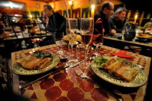 una mesa con dos platos de comida y copas de vino en L'Acilya, en Roussillon en Isère