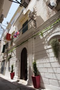 a building with two potted plants and a balcony at Relais Parallelo 41 in Vieste
